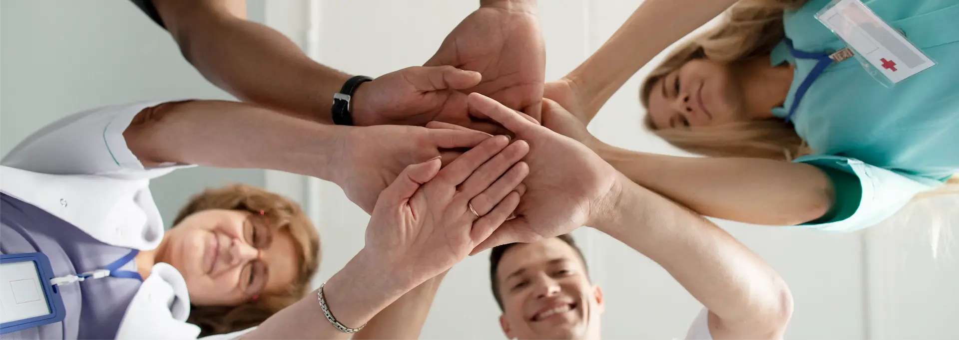 Equipo de salud uniendo las manos en círculo.